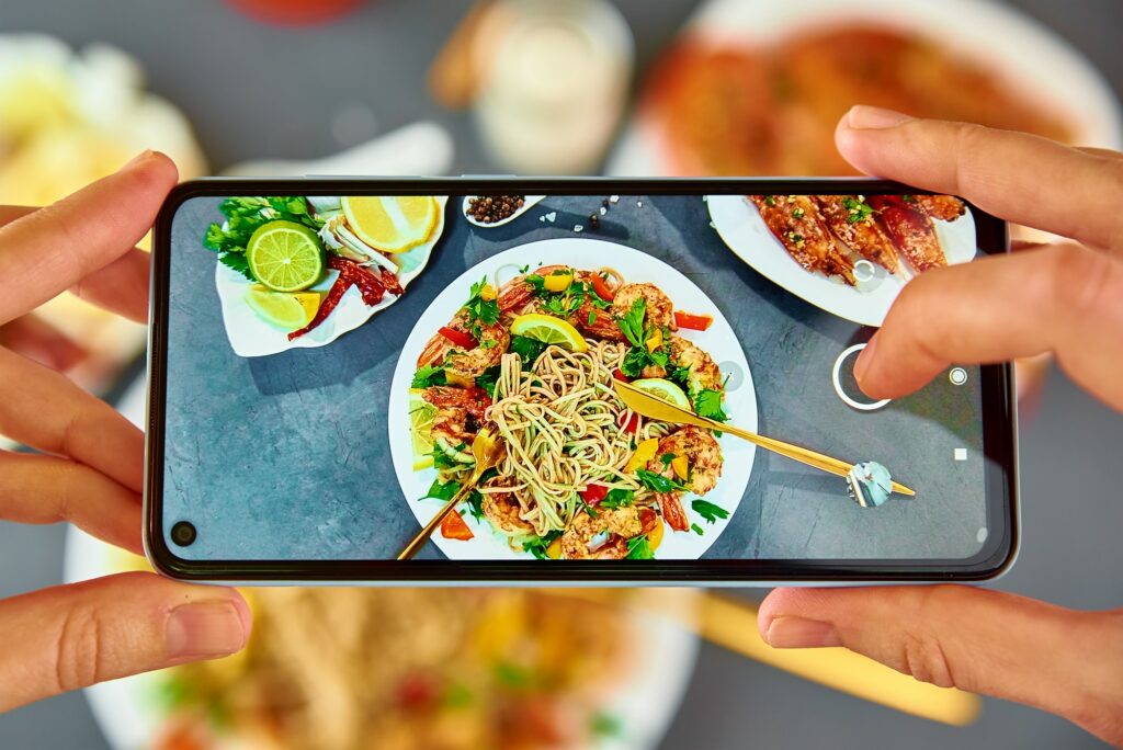 Taking photo of stir fry noodle with smartphone for social media