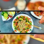 Taking photo of stir fry noodle with smartphone for social media